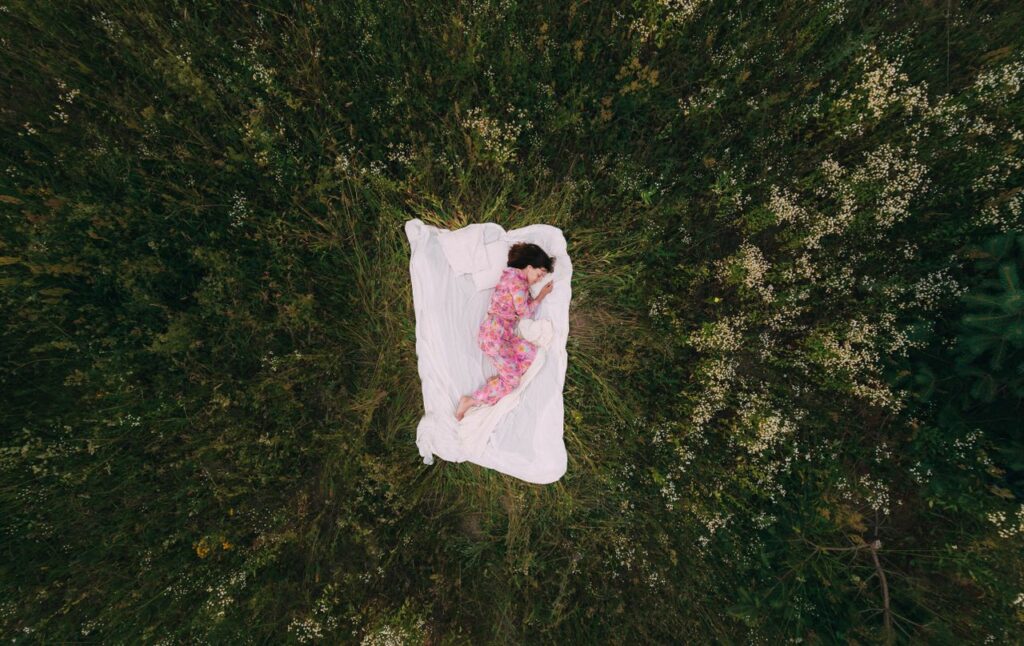 Imagem de uma mulher dormindo em meio a floresta num sonho, para o subtitulo oque sao os sonhos na neurociencia.